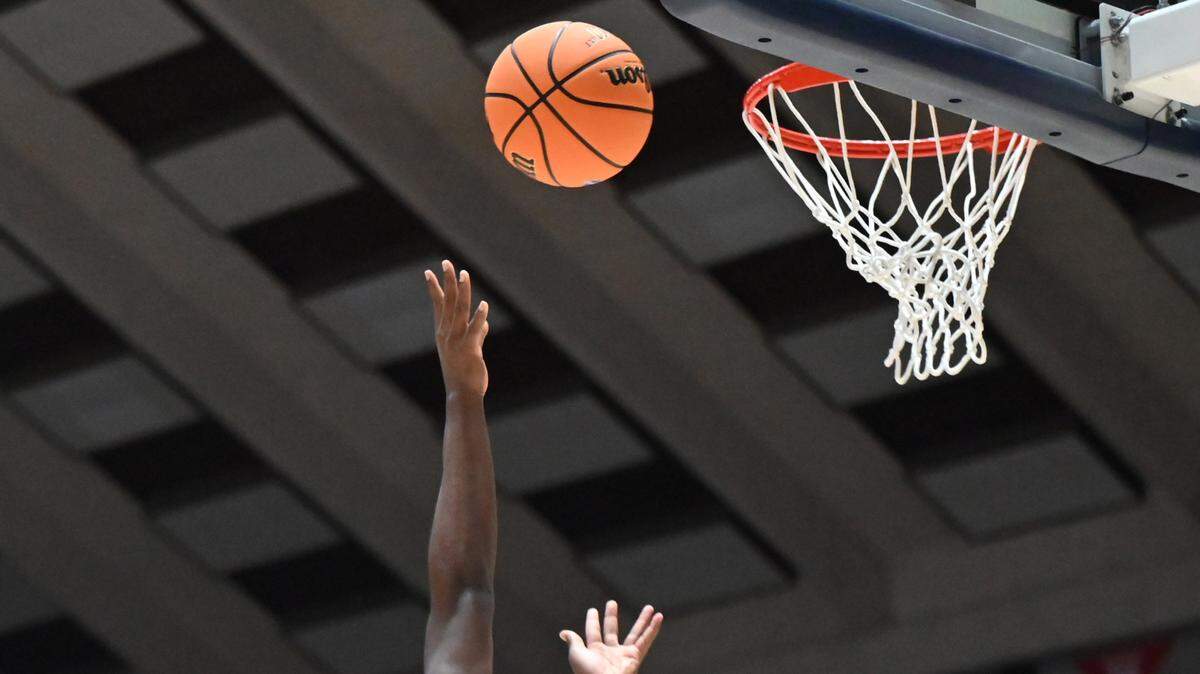 Two players reach for a rebound during a Georgia state basketball tournament game in Macon.