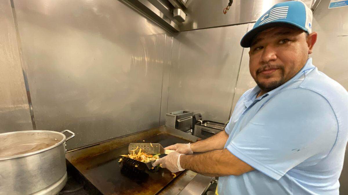 Jose Flores, who owns Don Pepe Taqueria & Country Diner with his wife, Yolanda Chavez, looks up from grilling.