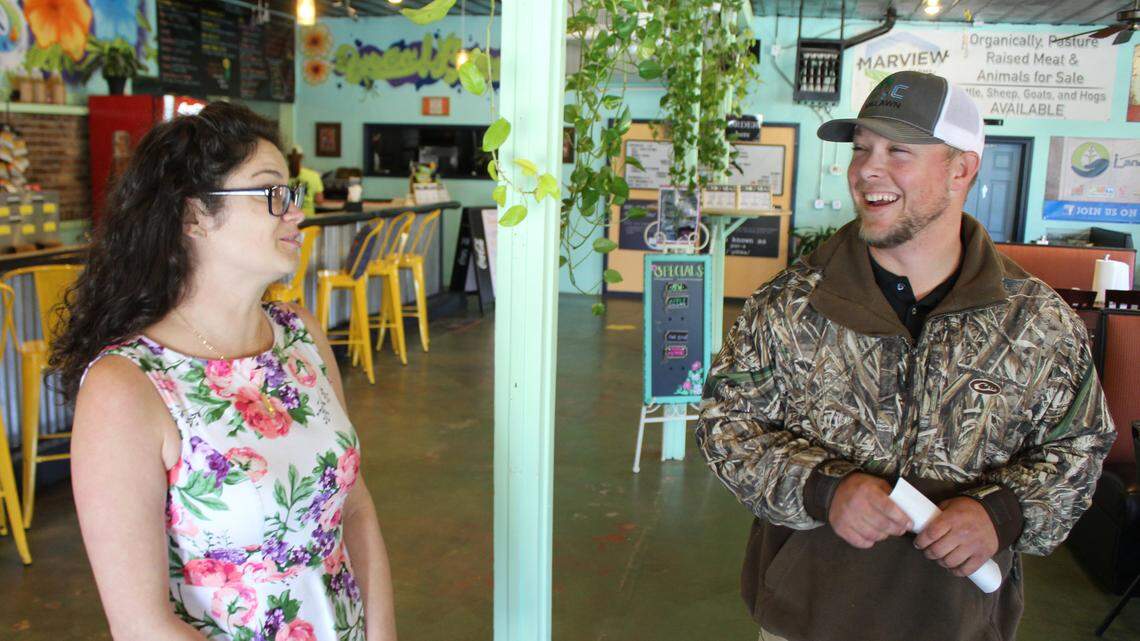 Tim Waller, co-owner of Georgia Landscape Co., smiles after Rikki Waite, owner of Grandma's Empanadas, gave him a check for $300 donated from customers over two days to help the company recover from the theft of its equipment.