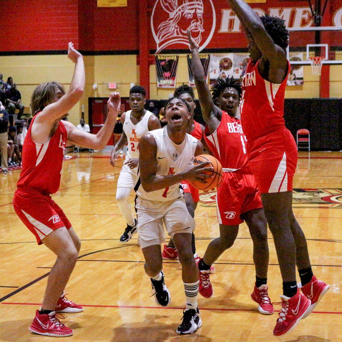 Northeast’s Travion Solomon (#1) goes for a layup between Berrien defenders during the Raiders’ 87-62 win in their first round state playoff game.