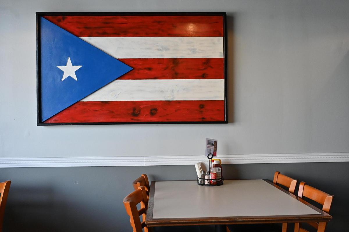 A Puerto Rican flag made of wood hangs on the wall of Caribbean Queens Latin Cuisine on Thursday, March 27, 2025, in Forsyth, Georgia. Owner Lisa Morales opened the Puerto Rican restaurant in downtown Forsyth in January.