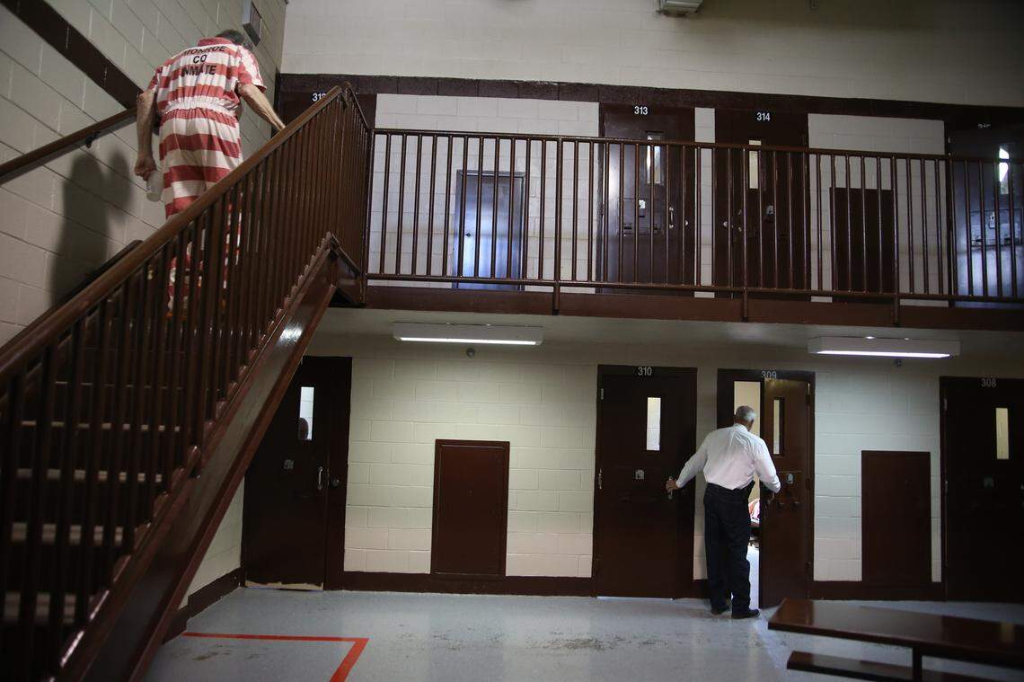 Monroe County Lt. Ricky Davis peers inside the cell of an inmate in the “hotel,” a jail dorm for men under medical observation.