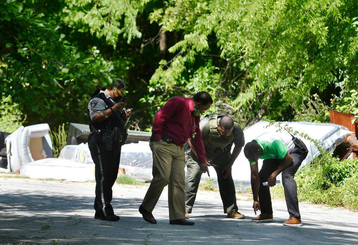 Bibb investigators walk along Churchill Street in Macon’s Unionville neighborhood after a citizen found the body of Amond Rashad Norwood, 26, under a pile of mattresses.