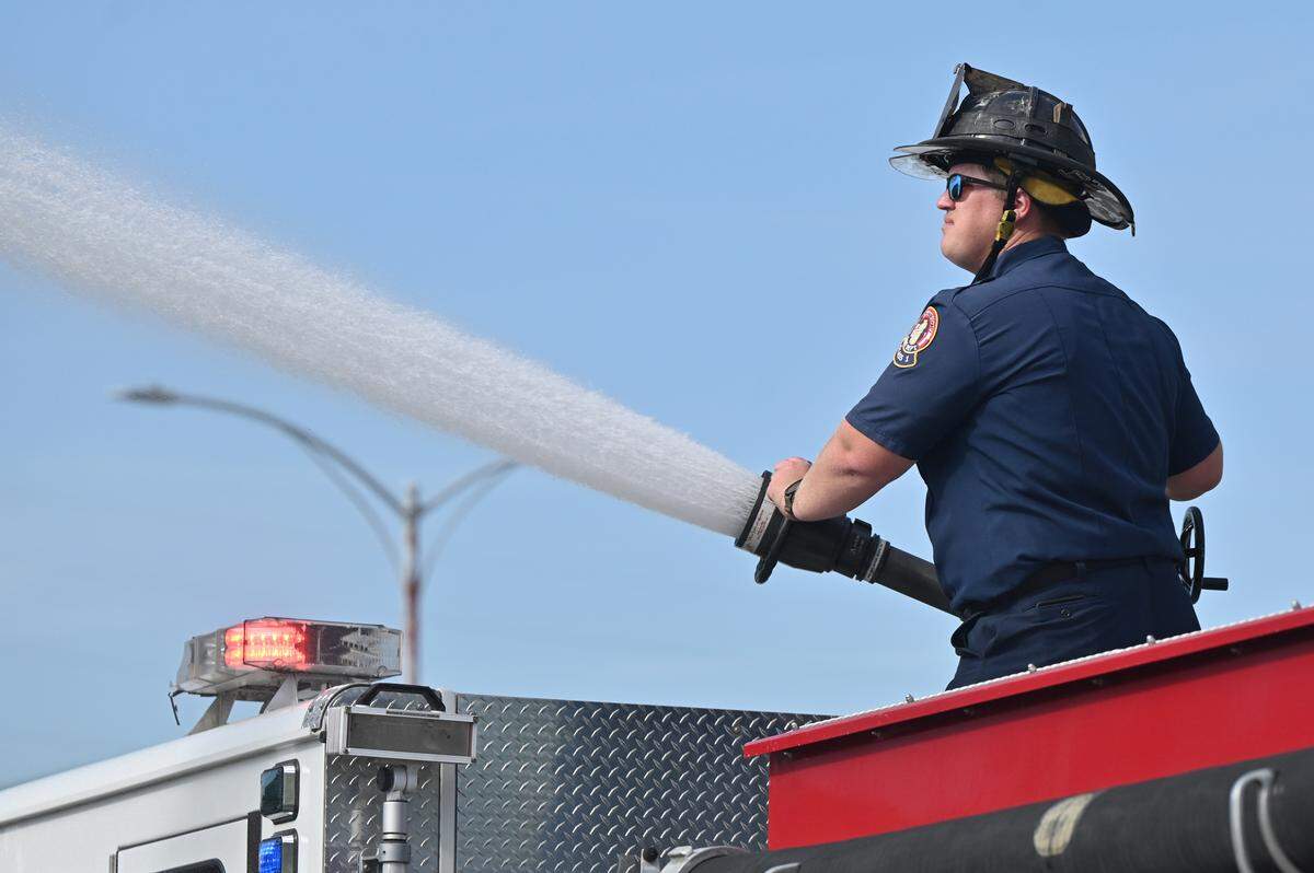 Macon-Bibb County firefighter Jeffrey Powell uses a fire hose to stop the spread of dust during a building demolition on Wednesday, April 1, 2026, off of Coliseum Drive in Macon, Georgia. The demolition of 237 Coliseum Drive adds to the land available for the development of the East Bank Project, the former Bibb Mill site and proposed mixed-use redevelopment project in East Macon. 