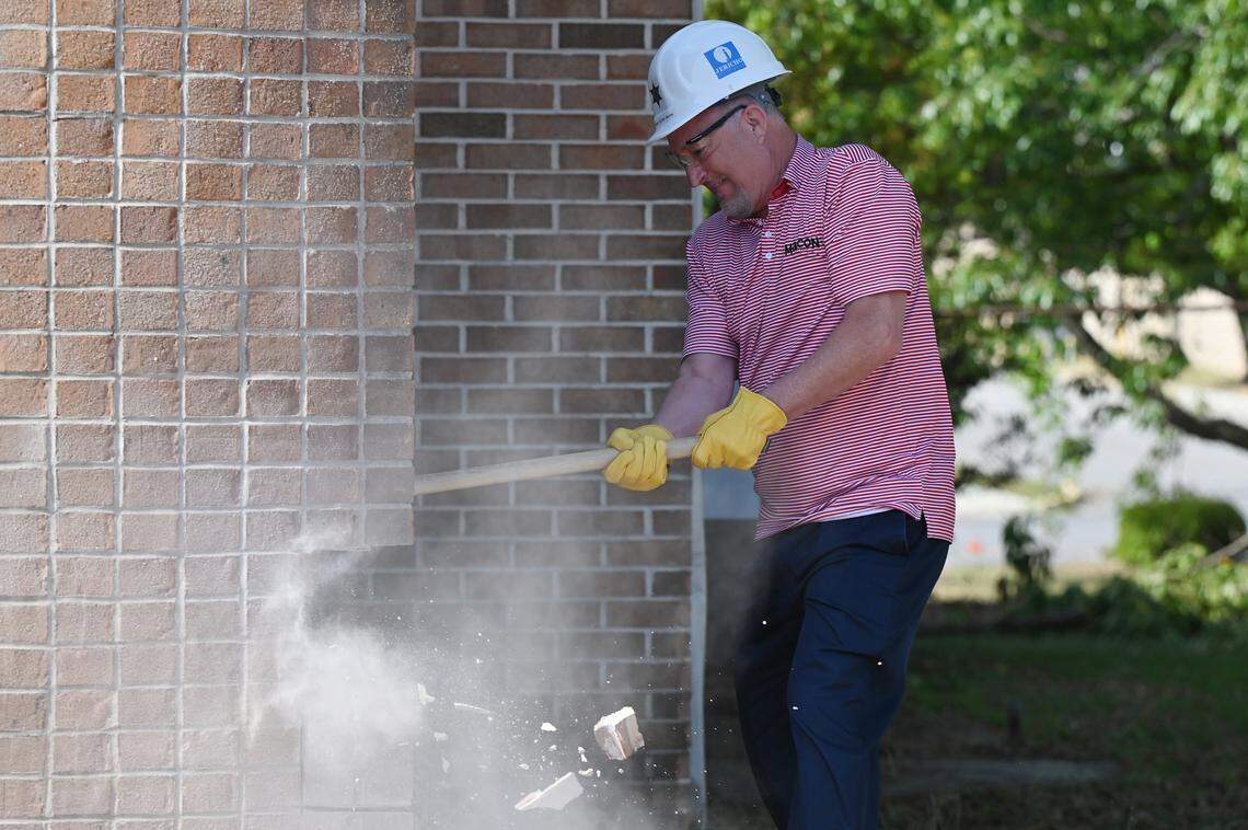 Macon-Bibb county mayor Lester Miller swings a sledge hammer as the first piece of demolition of the James F. Higgins Memorial Building on Thursday, April 16, 2026, in Macon, Georgia. The building formerly housed the investigation unit at the sheriff’s office.