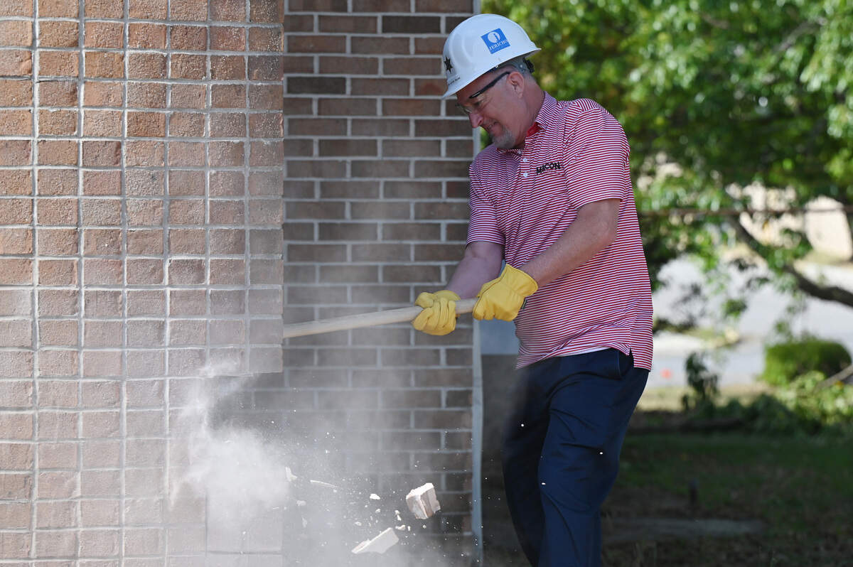 Macon-Bibb county mayor Lester Miller swings a sledge hammer as the first piece of demolition of the James F. Higgins Memorial Building on Thursday, April 16, 2026, in Macon, Georgia. The building formerly housed the investigation unit at the sheriff’s office.