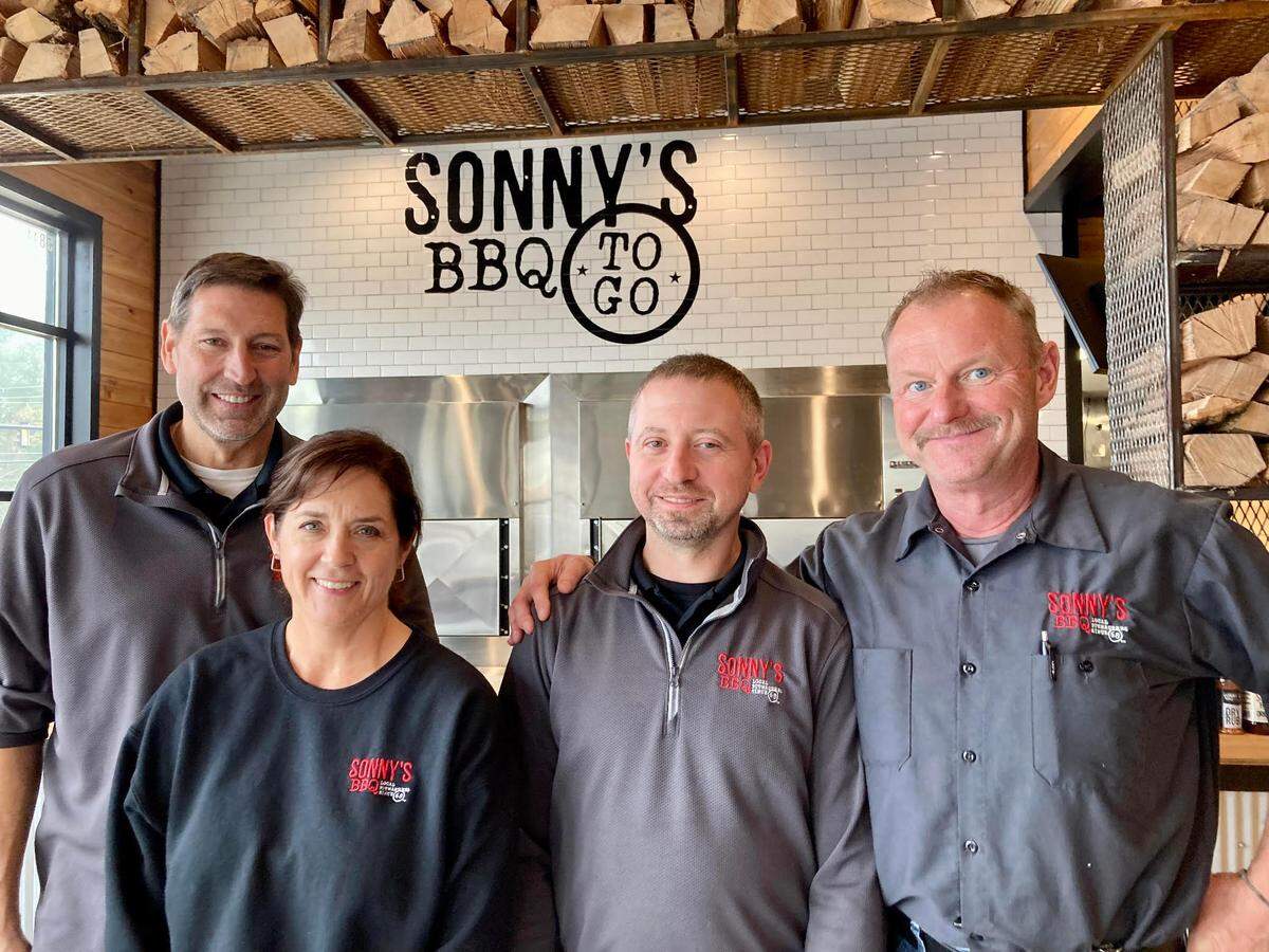 From left, Sonny’s BBQ owner Brad Fink and his wife, Gina, Duane Hartenhoff, general manager, and Steve Jackowiak, area director.
