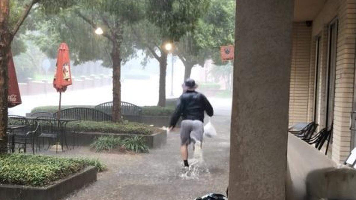 A Mercer Village patron dashes through stormwater runoff during a spring thunderstorm outside Francar’s restaurant. The Macon Water Authority responded that week and drained the sewer a couple of days after the flash flood.