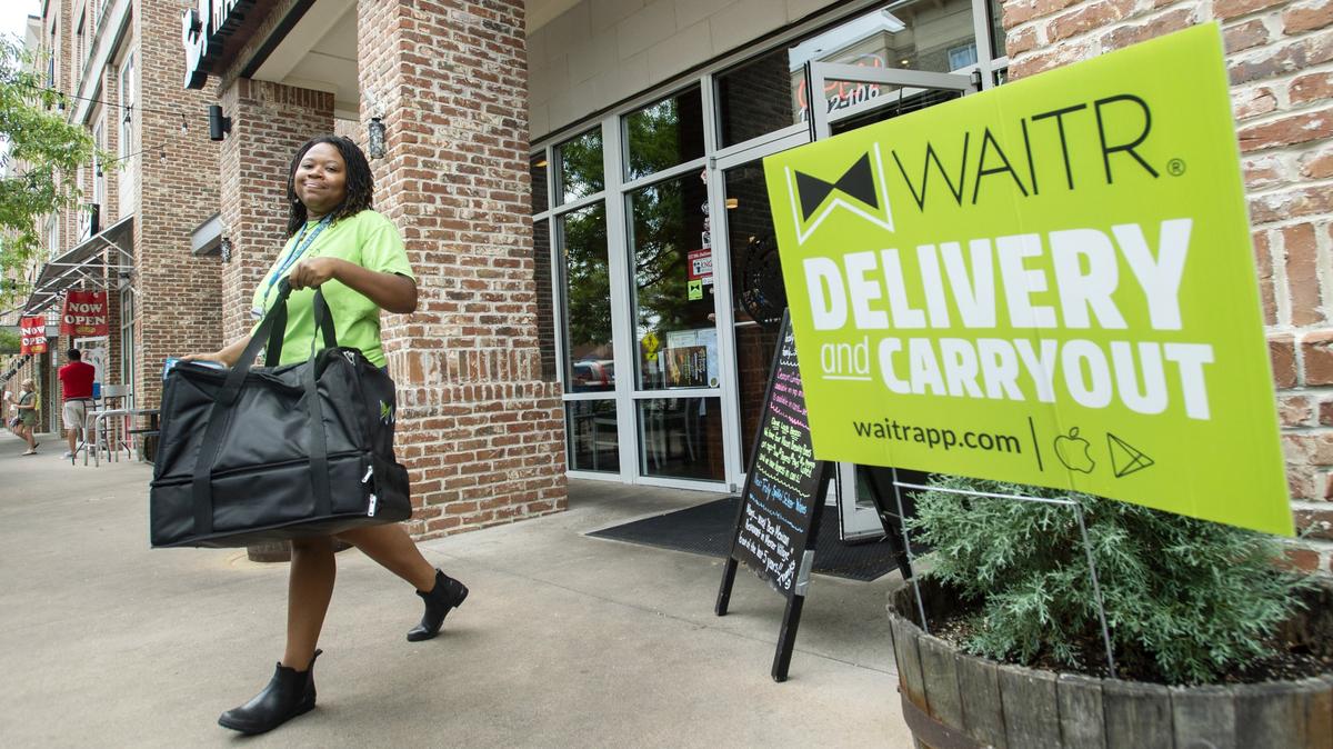 A Waitr driver walks out of Margaritas Mexican Grill in Mercer Village Thursday afternoon after picking up an order.