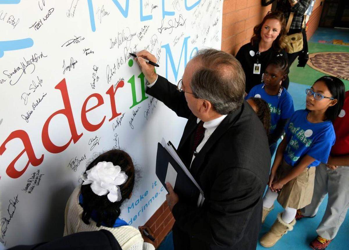 In this file photo from Macon 23, 2017, Mayor Robert Reichert signs the “We Need The Leader in Me” banner at Carter Elementary Thursday morning.