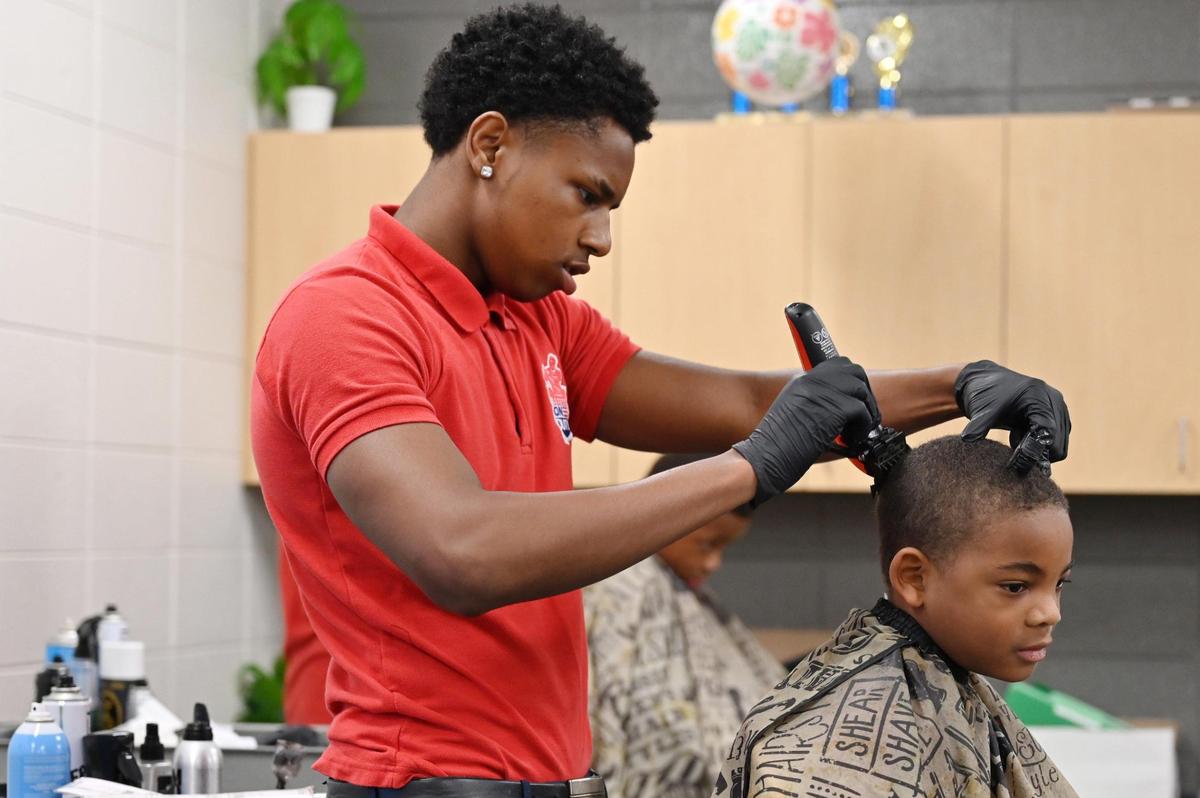 Ojore “OJ” Harrell, 17, buzzes the hair of a student on Monday, May 19, 2025, at Union Elementary School in Macon, Georgia. “It’s definitely a blessing for sure to have a skill and give back to the kids that’s around my age,” he said about giving out free haircuts to kids. “They ain’t too far from behind me.”