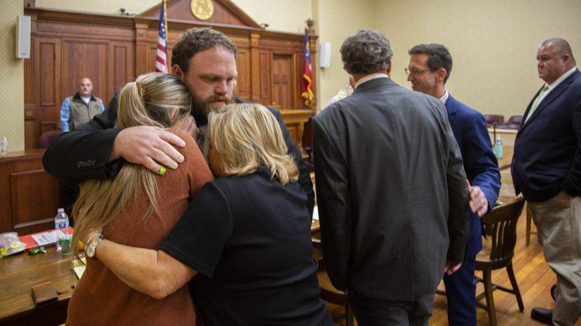 Rhett Scott hugs his wife Kelly Scott, left, and his mother Karen Scott, right, after being found not guilty of felony murder in the death of Eurie Martin in 2017.