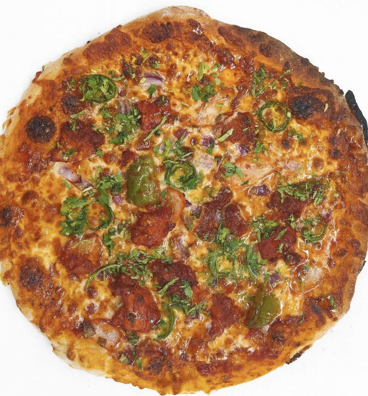 “Chili Madness” pizza from Slice & Spice that’s made with red sauce, mozzarella, chili chicken or paneer, red onions, jalapeños, red chili flakes, and crispy garlic chips.
