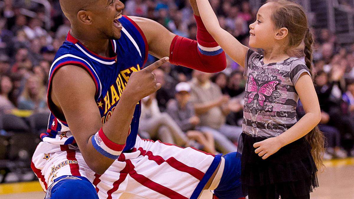 SPECIAL TO THE TELEGRAPHScooter Christensen helps a young fan spin a basketball at a Harlem Globetrotters performance.