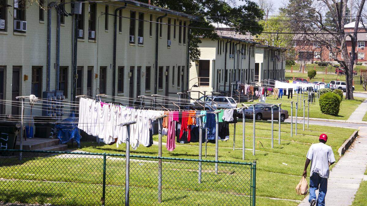 A man carries bags along a sidewalk in Tindall Heights Homes in this April 2015 file photo. The demolition of public housing at Tindall Heights has been approved by the federal government, according to the Macon-Bibb County Housing Authority.