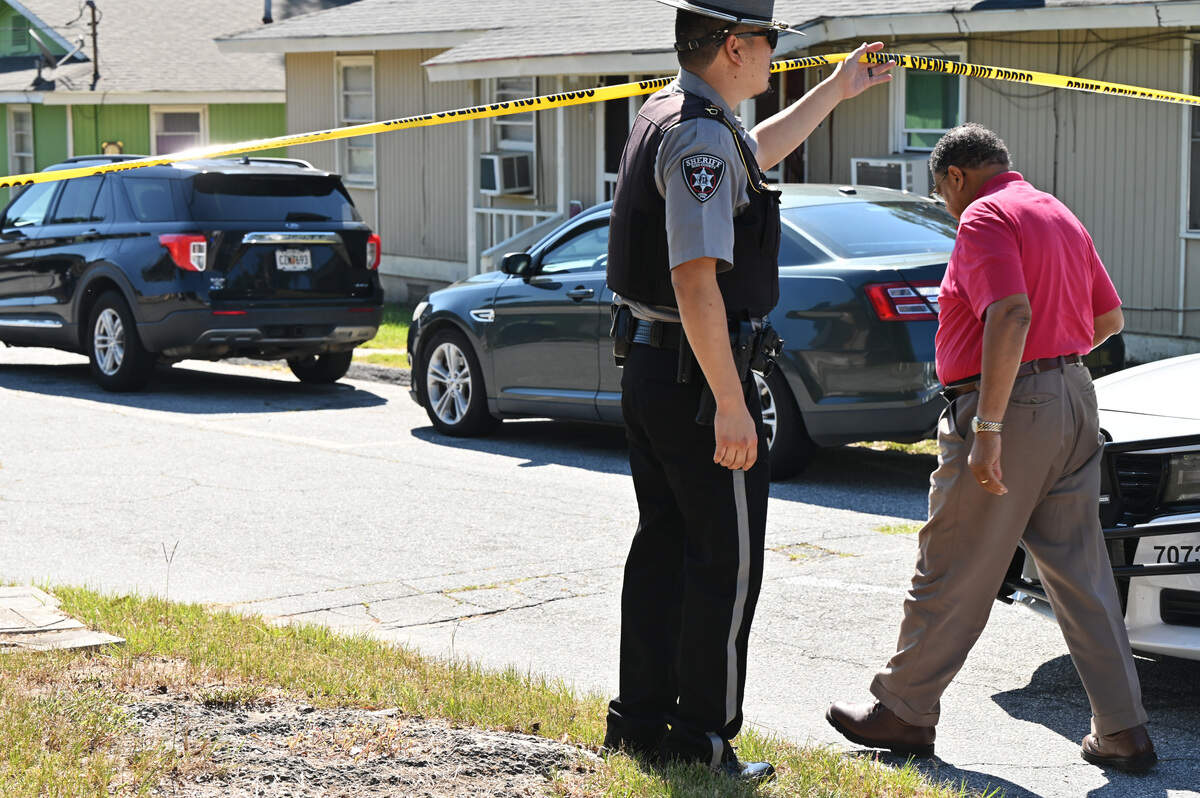 Bibb County Coroner Leon Jones (right) walks under police tape outside of Sanford Arms Apartments on Tuesday, Sept. 11, 2025, in Macon, Georgia. A dead body was found in an east Macon neighborhood Thursday morning and a death investigation was underway, according to the Bibb County Coroner’s Office.