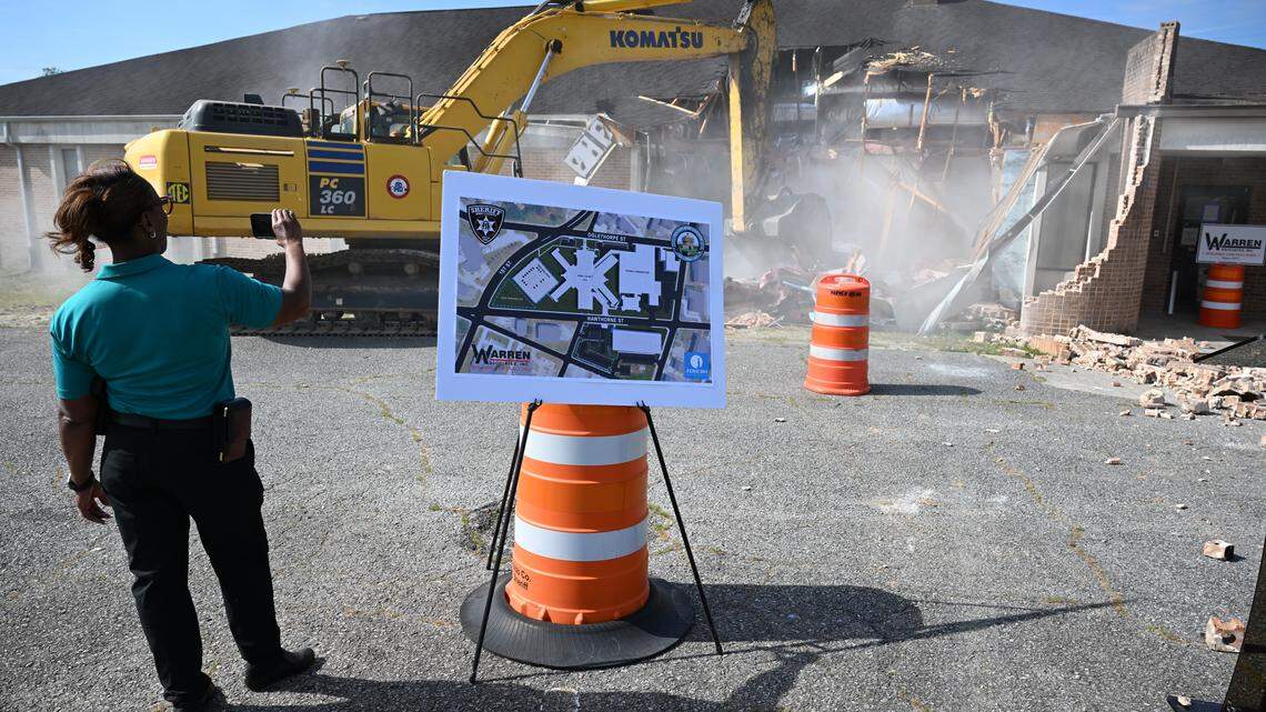 Captain Linda Howard with the Bibb County Sheriff’s Office records the demolition of James F. Higgins Memorial Building on her phone on Thursday, April 16, 2026, outside of the Bibb County Jail. The demolition began the first phase of the Bibb County Jail renovation, which will begin with building an updated parking lot where the building stood. 