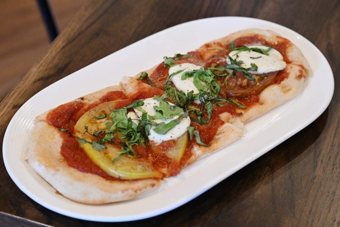 The margherita flatbread from J. Reid’s Tavern features heirloom tomatoes, mozzarella, basil, arugula and sauce made in house. 