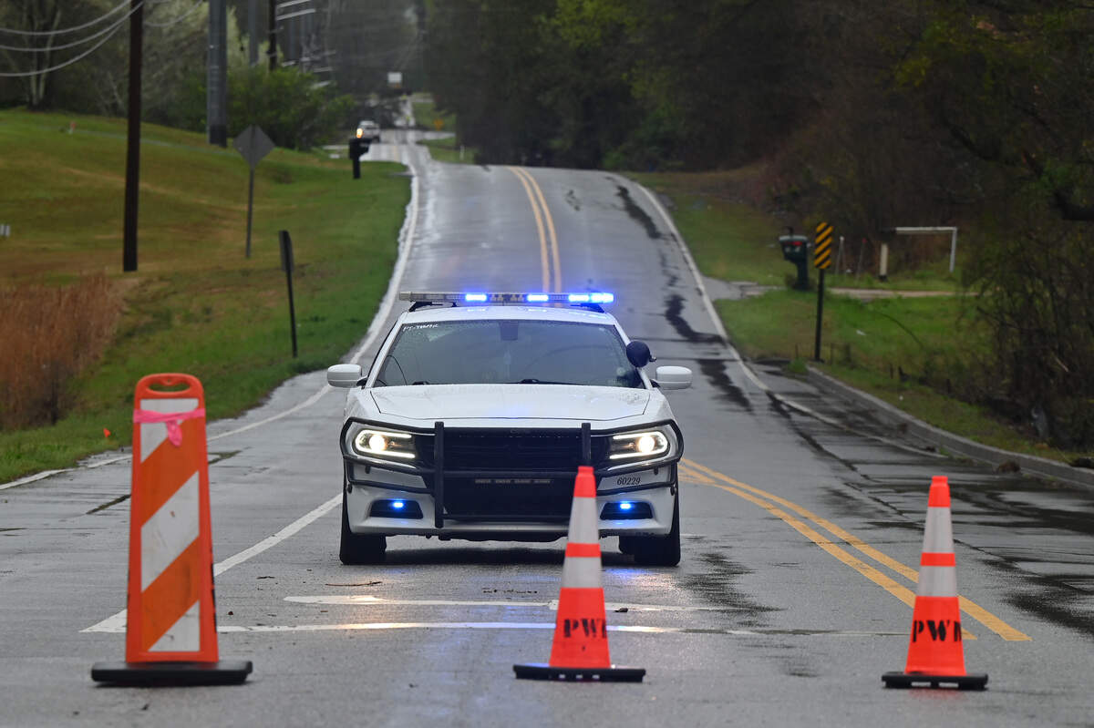 A Bibb County Sheriff’s Office patrol car sits behind cones blocking Thomaston Road on Thursday, March 12, 2026, in Macon, Georgia. Severe storms early Thursday morning resulted in several outages and road closures.