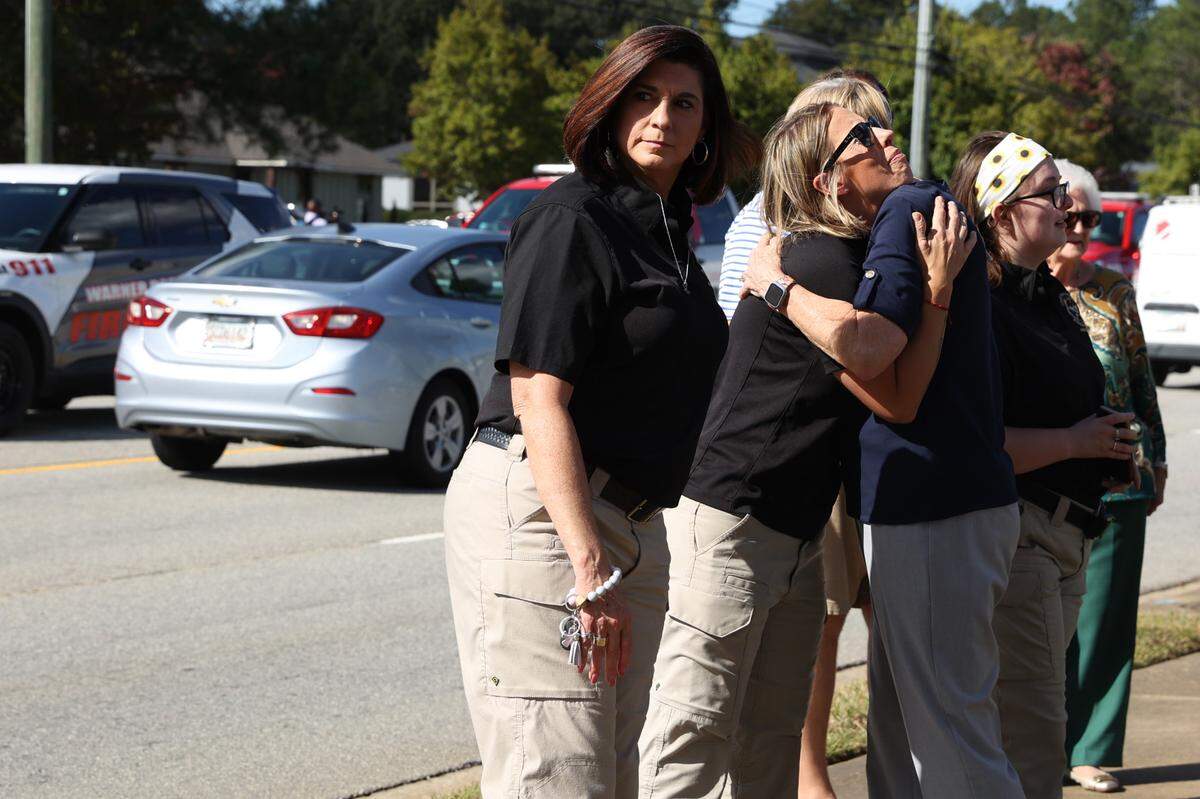 Members of the Houston County Sheriff’s Office embrace after a procession down Carl Vinson Parkway honoring the late Houston County Sheriff Cullen Talton on Tuesday, Oct. 22, 2024, outside of the Houston County Sheriff’s Department in Warner Robins, Georgia. Sheriff Talton died peacefully on Saturday at age 92 and served nearly 52 years as sheriff.