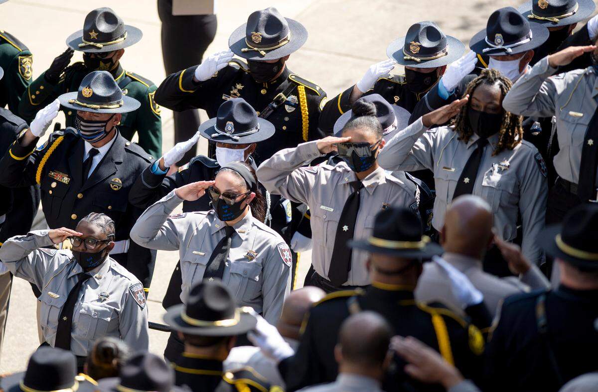 Bibb County deputies salute as members of the Bibb County SheriffÕs Honor Guard carry the casket holding former Bibb County deputy Christopher Knight to a hearse outside the Macon City Auditorium Tuesday after funeral services ended.