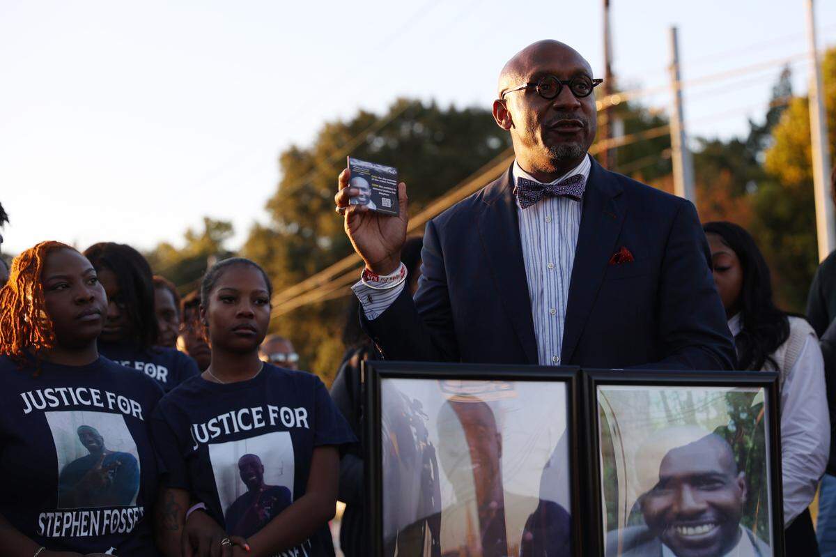 Attorney Mawuli Davis of Davis Bozeman Law holds up cards with a link to a petition for the Bibb County Sheriff’s Department to release the body cam footage from the death of Stephen Fossett during a vigil for Fossett on Tuesday, Oct. 22, 2024, outside of the Bibb County Jail in Macon, Georgia. Fossett’s death was ruled a homicide earlier this month.