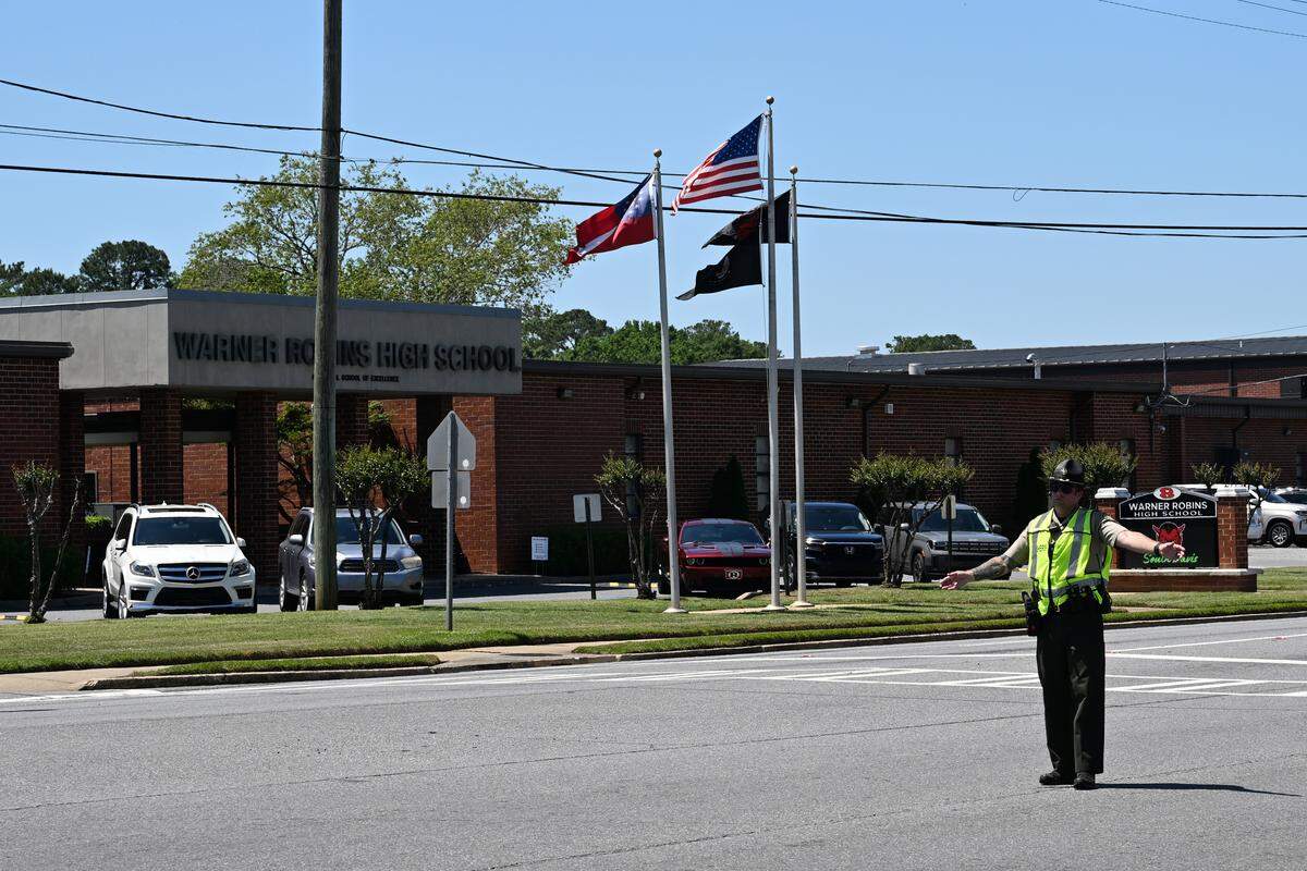 A member of the Houston County Sheriff’s Office directs traffic outside of Warner Robins High School on Monday, May 18, 2026, in Warner Robins, Georgia. The Houston County Sheriff’s Office blocked roads outside the high school after a bomb threat was called in Monday afternoon. 