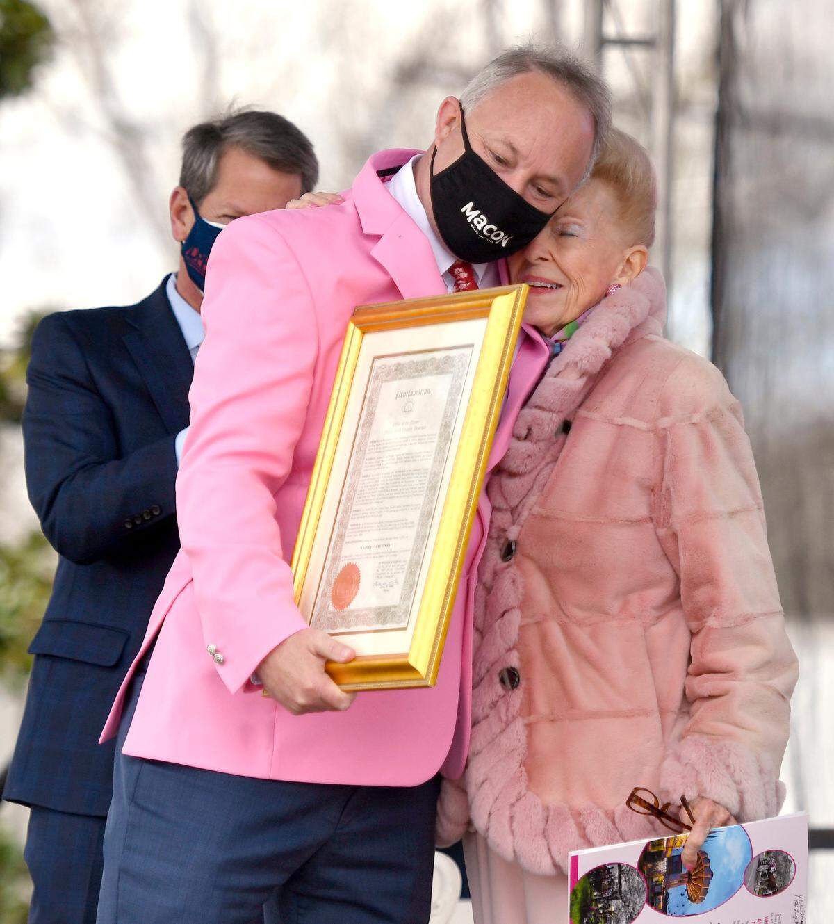 Macon-Bibb County Mayor Lester Miller hugs Cherry Blossom Festival founder Carolyn Crayton after reading a proclamation changing the name of Central City Park to Carolyn Crayton Park Friday during the opening ceremonies of the Cherry Blossom Festival.