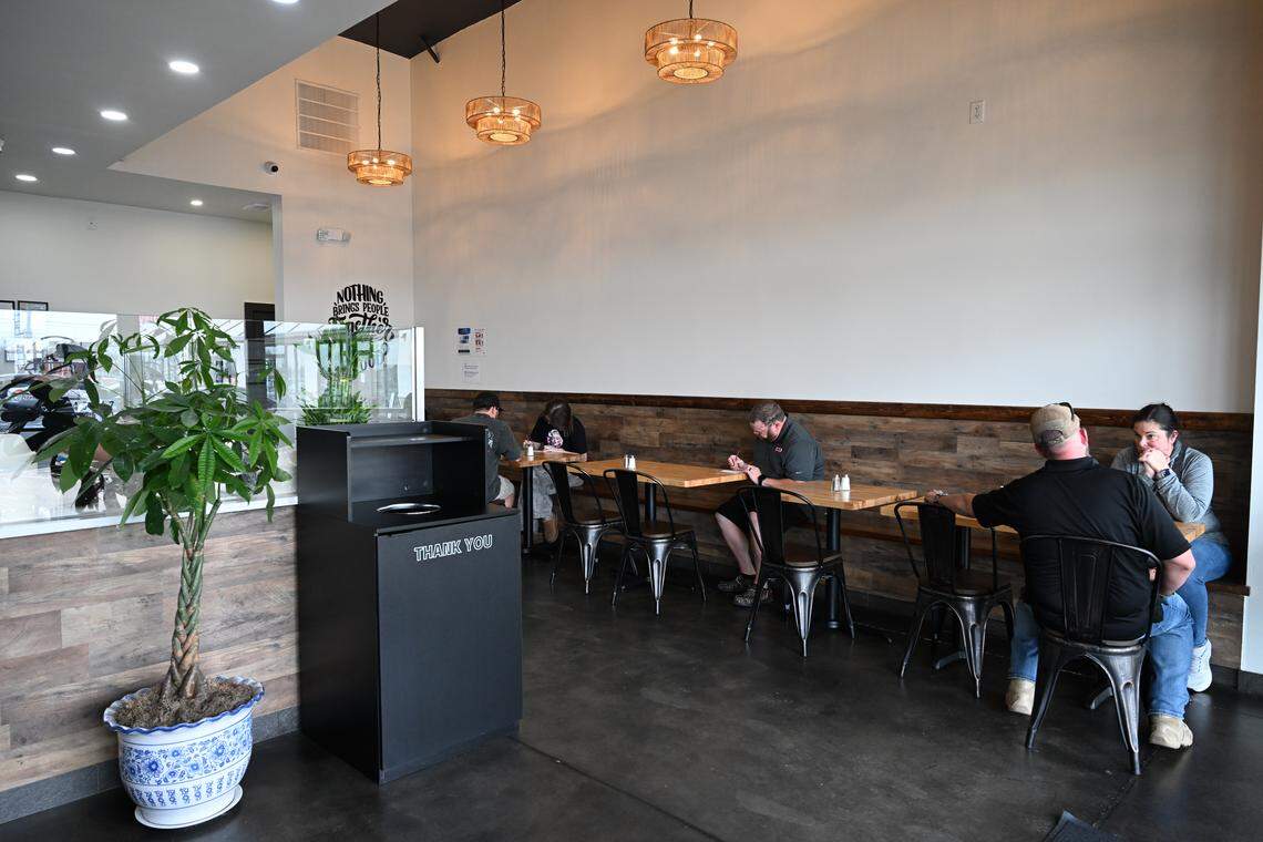 Bench seating with tables and chairs line the wall of Robins Poke & Ramen in Warner Robins. The restaurant, which also has some high bench seating in front of the windows, also offers takeout, online ordering and delivery via DoorDash and Uber Eats.