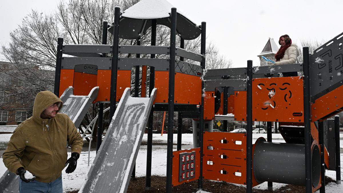 Mercer University seniors Bradley Anderson (left) and Kendall Boyd play on the Tatnall Square Park playground in the snow on Sunday, Jan. 18, 2026, in Macon, Georgia. The National Weather Service expected Macon to receive 1 to 2 inches of snow on Sunday.