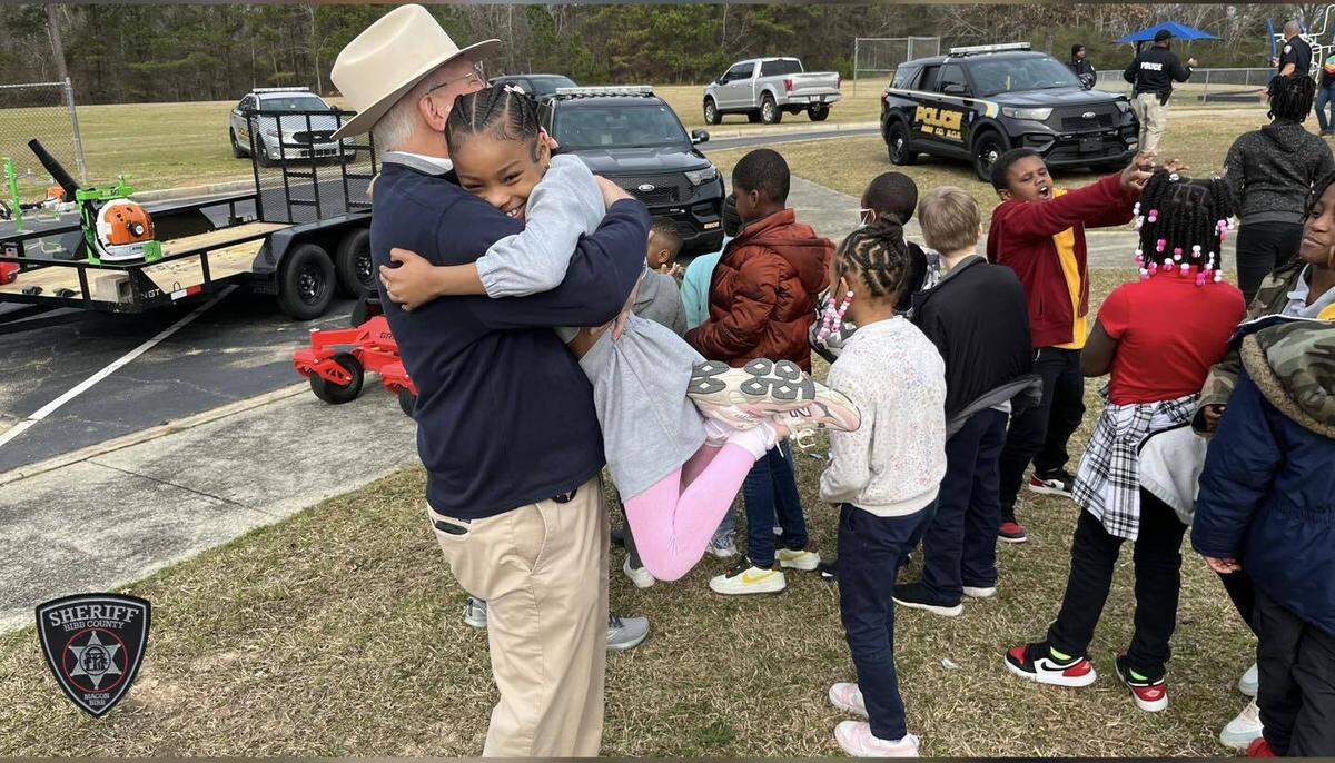 Bibb County Sheriff David Davis embraces a student recently at the Union Elementary School Career Day.