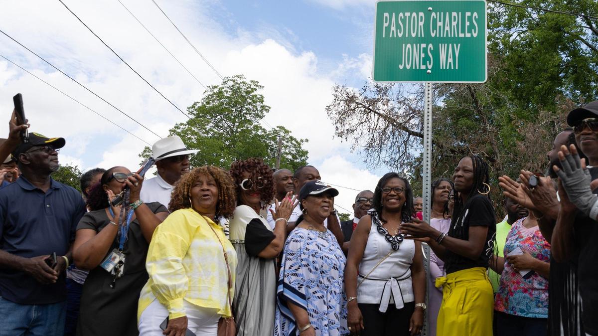 Family, friends and community members unveil the sign for Pastor Charles Jones Way on Friday, June 28, 2024, on Plant Street in Macon, Georgia. Jones, who passed away earlier this month, served as the pastor of Greater Rising Star Full Gospel Tabernacle Church for almost 30 years and as a city councilman for 12 years.