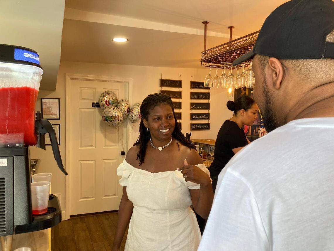 Ebony Lewis, owner of La’Vino Wine Bar, talks with a customer.
