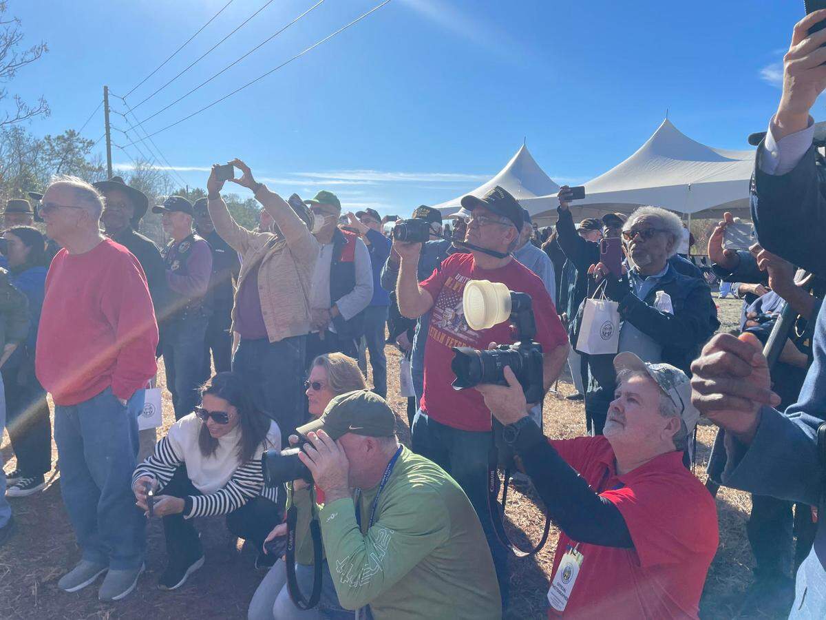 People take photos of a sign unveiling at the future home of a Vietnam Veterans Memorial in Warner Robins.