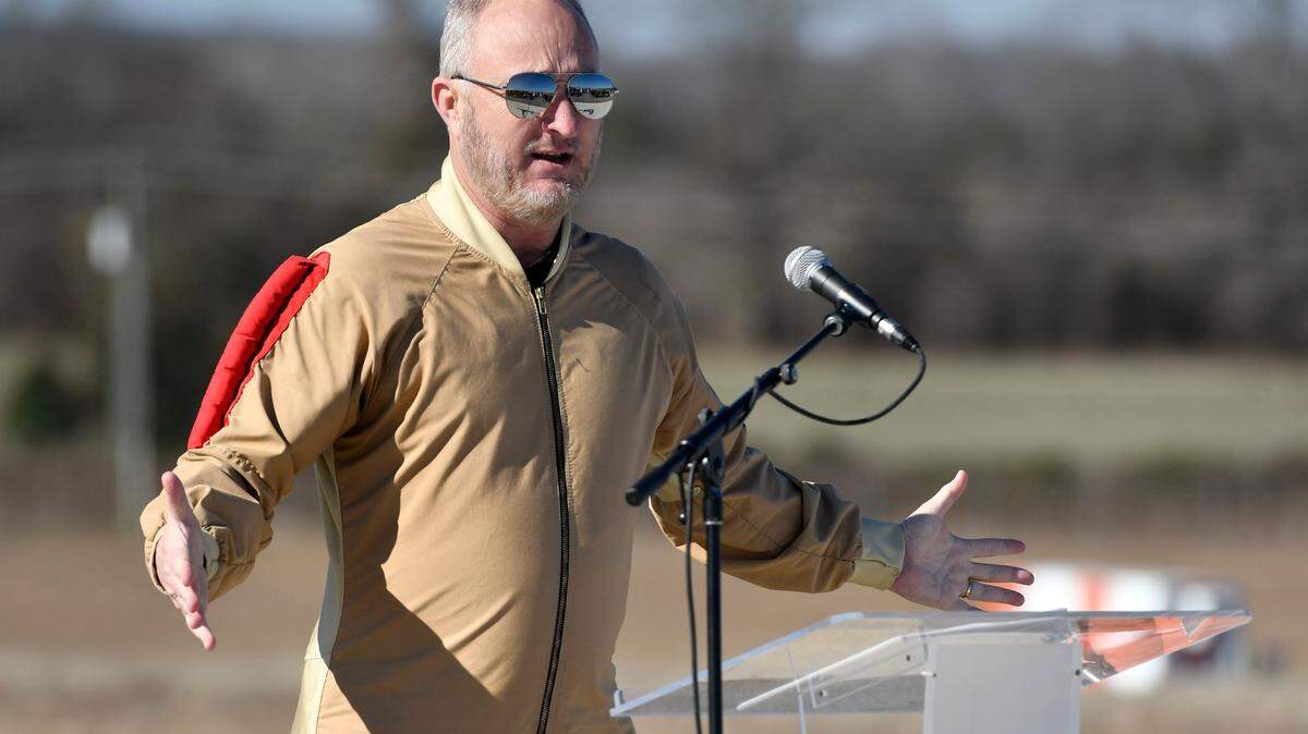 Mayor Lester Miller shows off his jumpsuit while speaking during a groundbreaking ceremony Tuesday for the runway expansion at the Middle Georgia Regional Airport. After discovering issues at the airport that would complicate the project, Macon-Bibb County canceled a construction contract for the work.