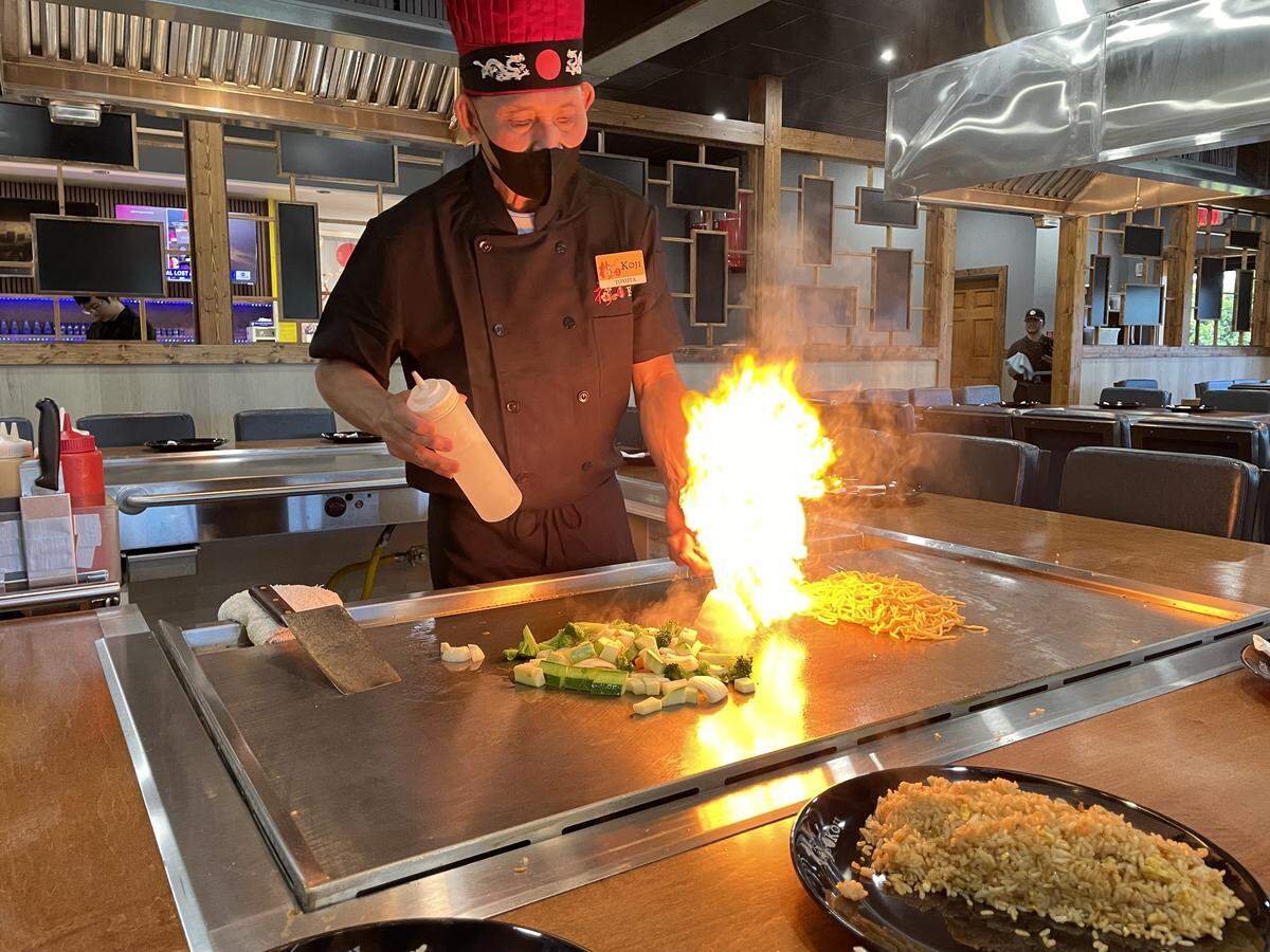 Chef Roy “Toyota” Nooh creates an onion volcano while cooking hibachi style at a teppanyaki table at the new Koji in Perry.