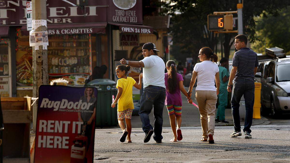 CAROLYN COLE/LOS ANGELES TIMESA family walks along 112th Street near Our Lady Queen of Angels School on Sept. 3 in New York City. Pope Francis will be visiting the school during his trip to New York next week.