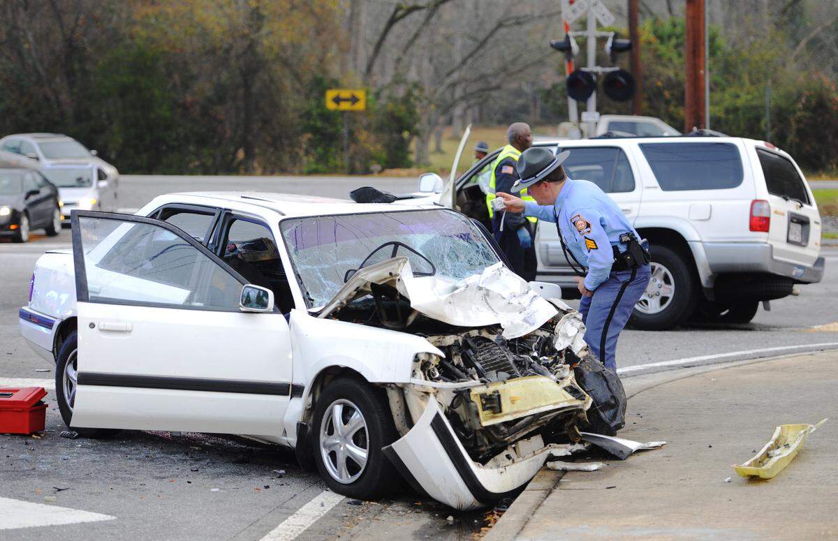 A Georgia State Patrol trooper makes photographs as he investigates a fatal accident at Forsyth and Tucker roads. Rescuers are trying to revive a victim of an accident that happened at about 7 a.m. at the intersection of Tucker and Forsyth roads near Wesleyan College.