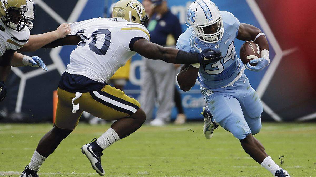 North Carolina running back Elijah Hood, right, runs the ball against Georgia Tech’s P.J. Davis in the second quarter of an NCAA college football game Saturday, Oct. 3, 2015, in Atlanta. North Carolina won 38-31.