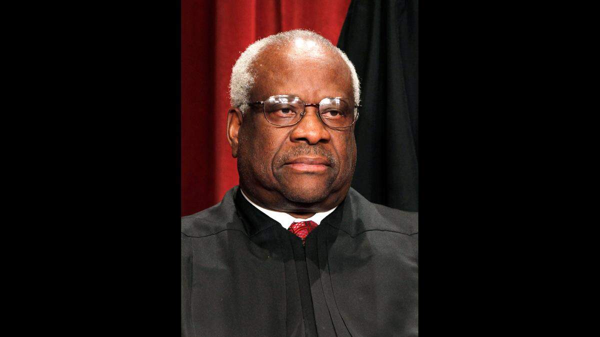 In this Oct. 8, 2010 file photo, Associate Justice Clarence Thomas is seen during the group portrait at the Supreme Court Building in Washington. Liberals and Democrats in Congress want Justice Thomas off the health care case. Conservative interest groups and Republican lawmakers say it’s Justice Elena Kagan who should sit it out. Neither justice is budging — the right decision, according to many ethicists and legal experts.