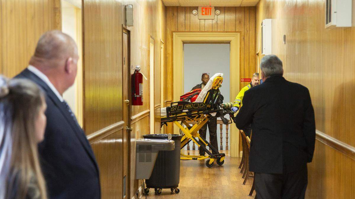 Emergency Medical Technicians wheel in a stretcher to take Muscogee County Assistant District Attorney George Lipscomb to the hospital after he fainted in court before opening arguments in the trial of three former Washington County Sheriff’s Deputies stemming from the 2017 death of Eurie Martin.
