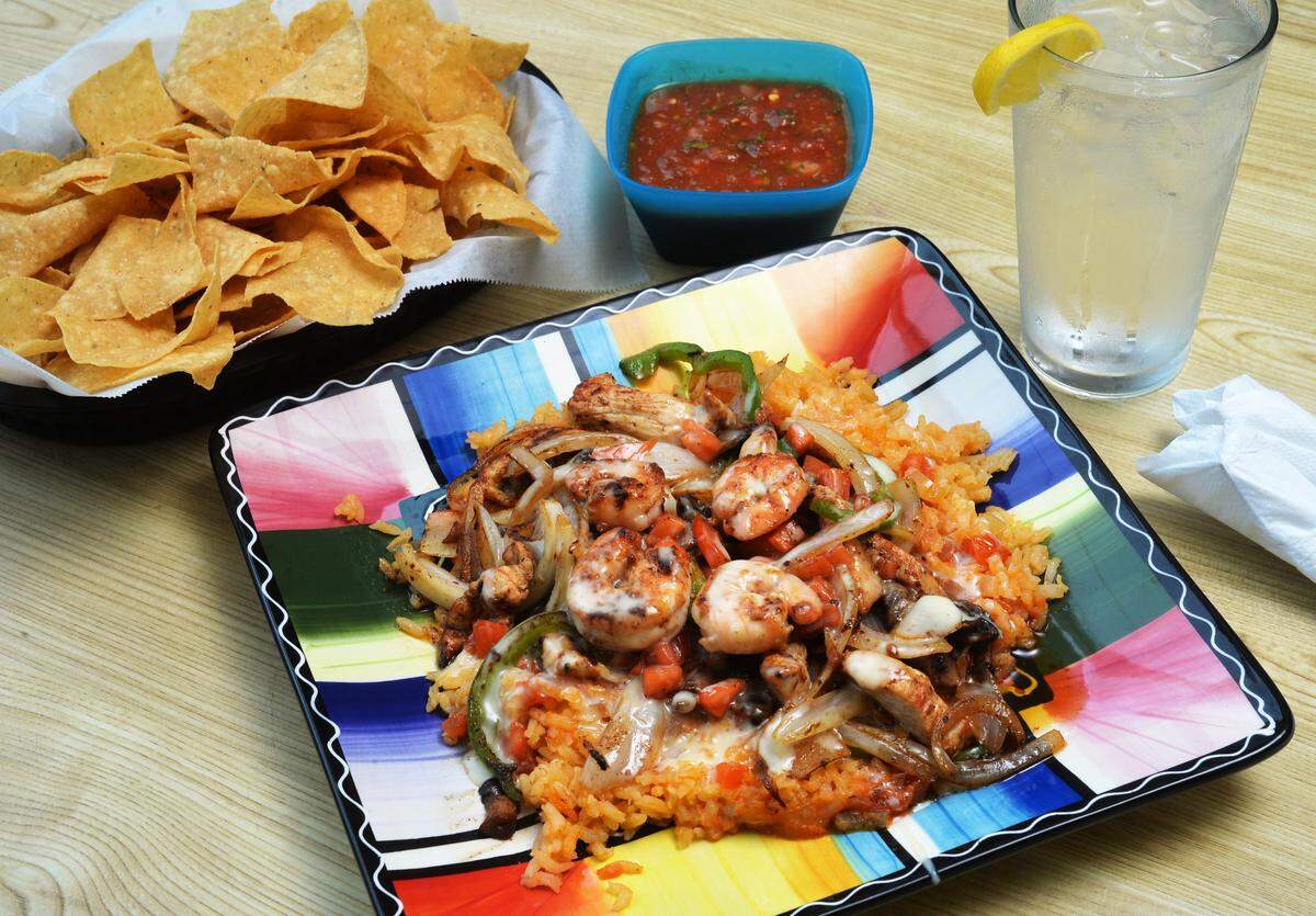 Guitarras Mexican Grill’s Macon Special, shrimp and steak over a bed of rice and vegetables, is served with salsa and chips.