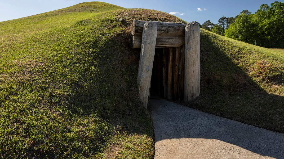 The Earth Lodge, dated to 1015 AD, was built by the Mississippian culture and later restored from archaeological evidence and is part of Ocmulgee Mounds National Historical Park.