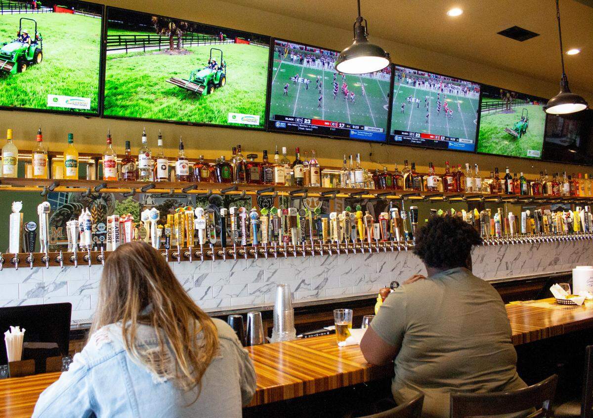 People have a meal at the bar at The Library Taphouse and Kitchen located at 1530 Mercer University Drive in Macon.