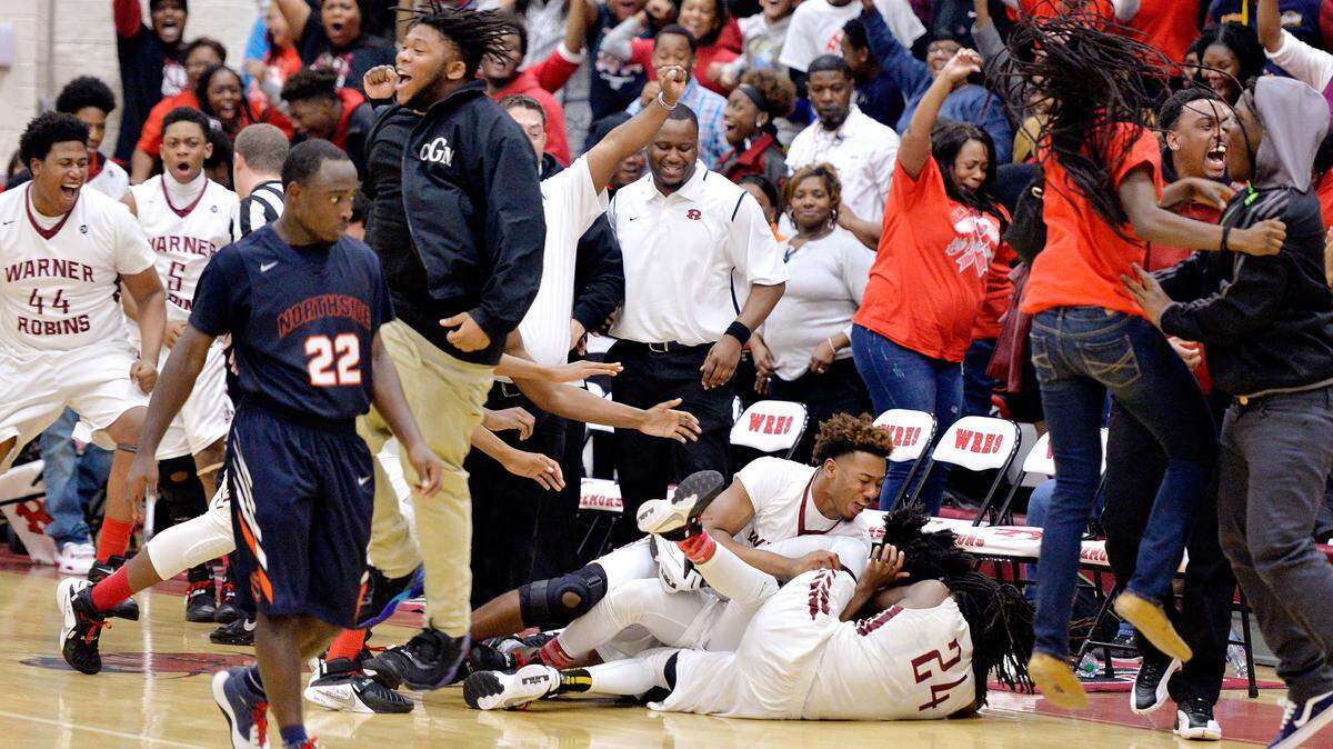 Warner Robins guard JaColbey Owens (4) celebrates with teammates after his game-winning shot in the Demons' 60-57 win over Northside on Saturday.
