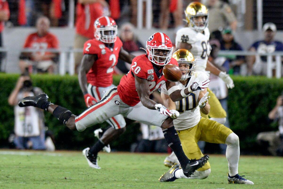 Georgia defensive back J.R. Reed (20) intercepts a pass intended for Notre Dame’s Chris Finke (10) during their game Saturday night in Athens.