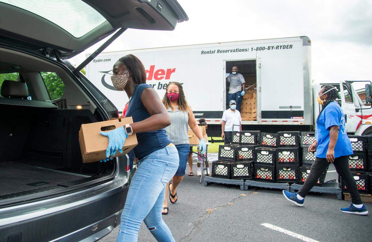 Volunteers hand out unload food boxes and milk Wednesday during a food drive at Community Church of God on Bethesda Avenue. The Church along with the Community Empowerment Center is giving away 500 family food boxes and 500 gallons of milk during the first of a scheduled weekly food drive at the Church. A food drive along with free Covid-19 drive-thru testing is scheduled for Sunday from 2 p.m. - 6 p.m. at First Baptist Church on Garmon St. in Warner Robins.