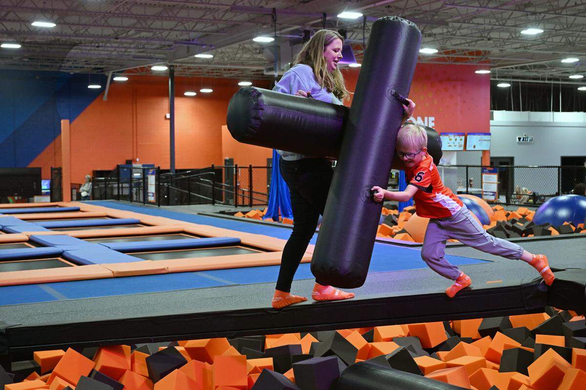 Kayla Mihalek (left) jousts with her son Zachary on the battle beam on Tuesday, March 17, 2026, inside of Sky Zone in Warner Robins, Georgia. Sky Zone is set to host its grand opening on Saturday.