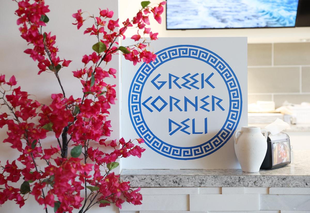 A sign advertising Greek Corner Deli sits on the counter in the restaurant on Wednesday, Sept. 4, 2024, in Macon, Georgia. Greek Corner Deli reopened in June and is now located on Spring Street after closing its downtown location in 2018.