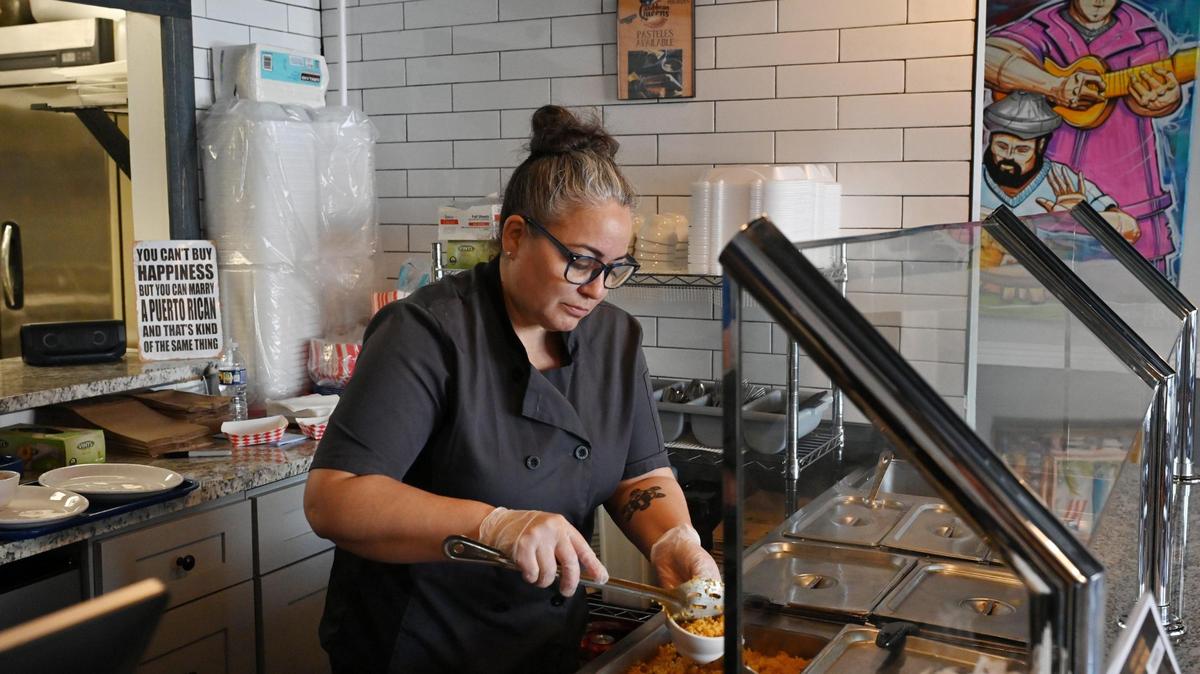 Caribbean Queens Latin Cuisine owner Lisa Morales scoops rice into a bowl at her restaurant on Thursday, March 27, 2025, in Forsyth, Georgia. Morales opened the Puerto Rican restaurant in January.